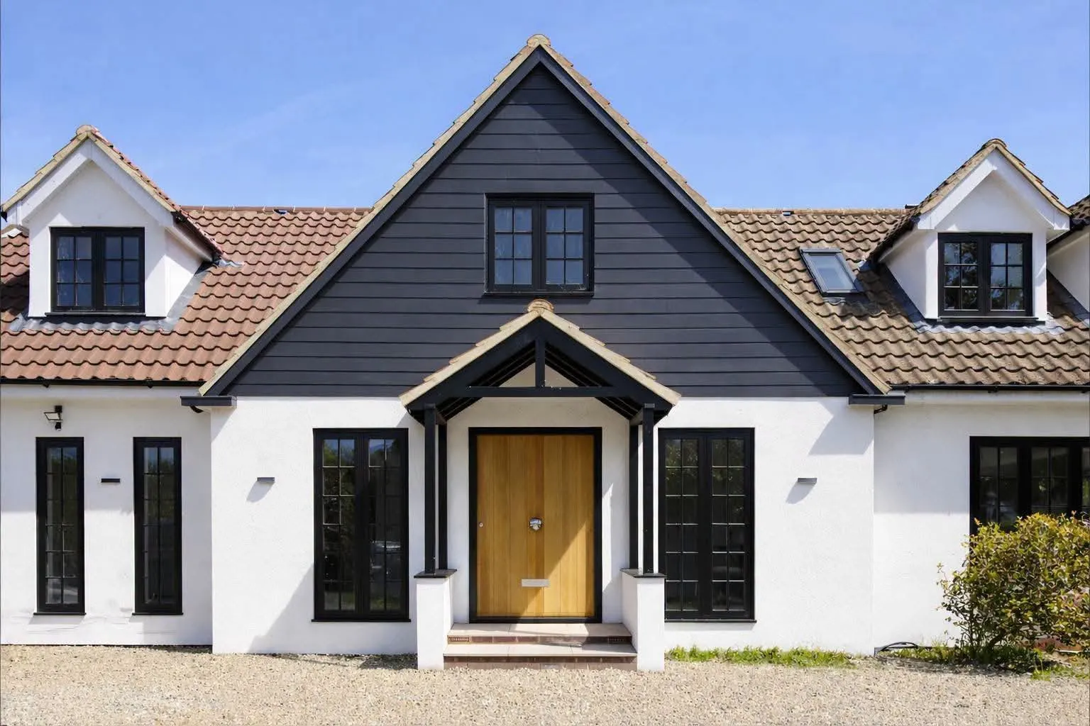 Detached home with crisp white external rendering and dark architectural cladding, completed by Prestige Plastering & Rendering